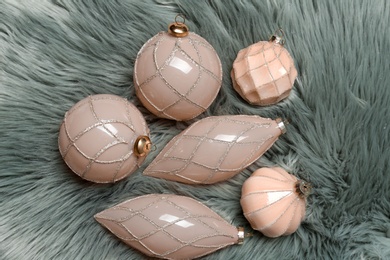 Photo of Collection of beautiful Christmas tree baubles on light grey faux fur, flat lay