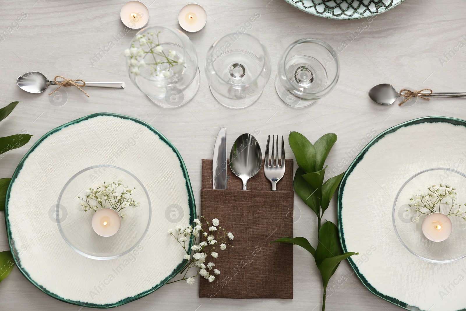 Photo of Elegant table setting with green plants on white wooden background, flat lay