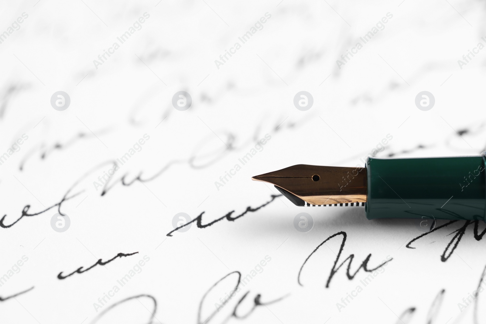 Photo of Elegant fountain pen on handwritten letter, closeup