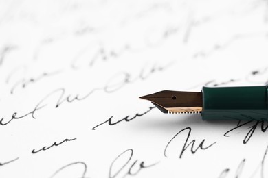 Photo of Elegant fountain pen on handwritten letter, closeup