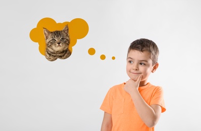 Image of Little boy on light background dreaming about cute kitten