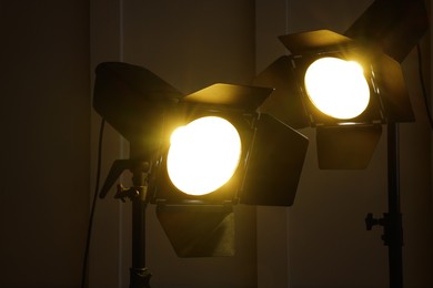 Bright yellow spotlights near wall indoors. Professional stage equipment