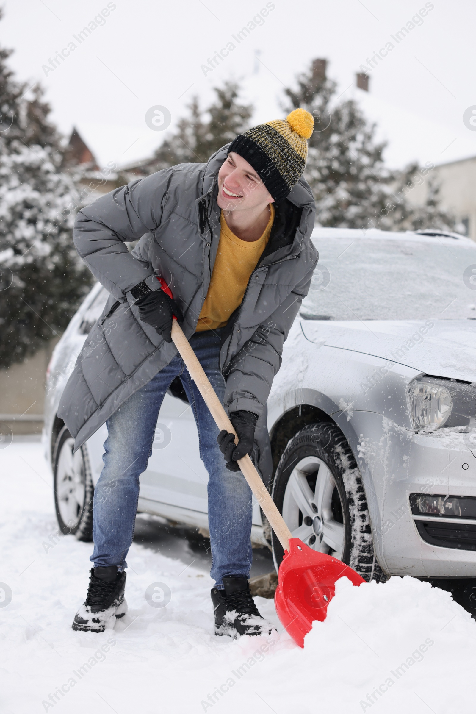 Photo of Man removing snow with shovel near car outdoors