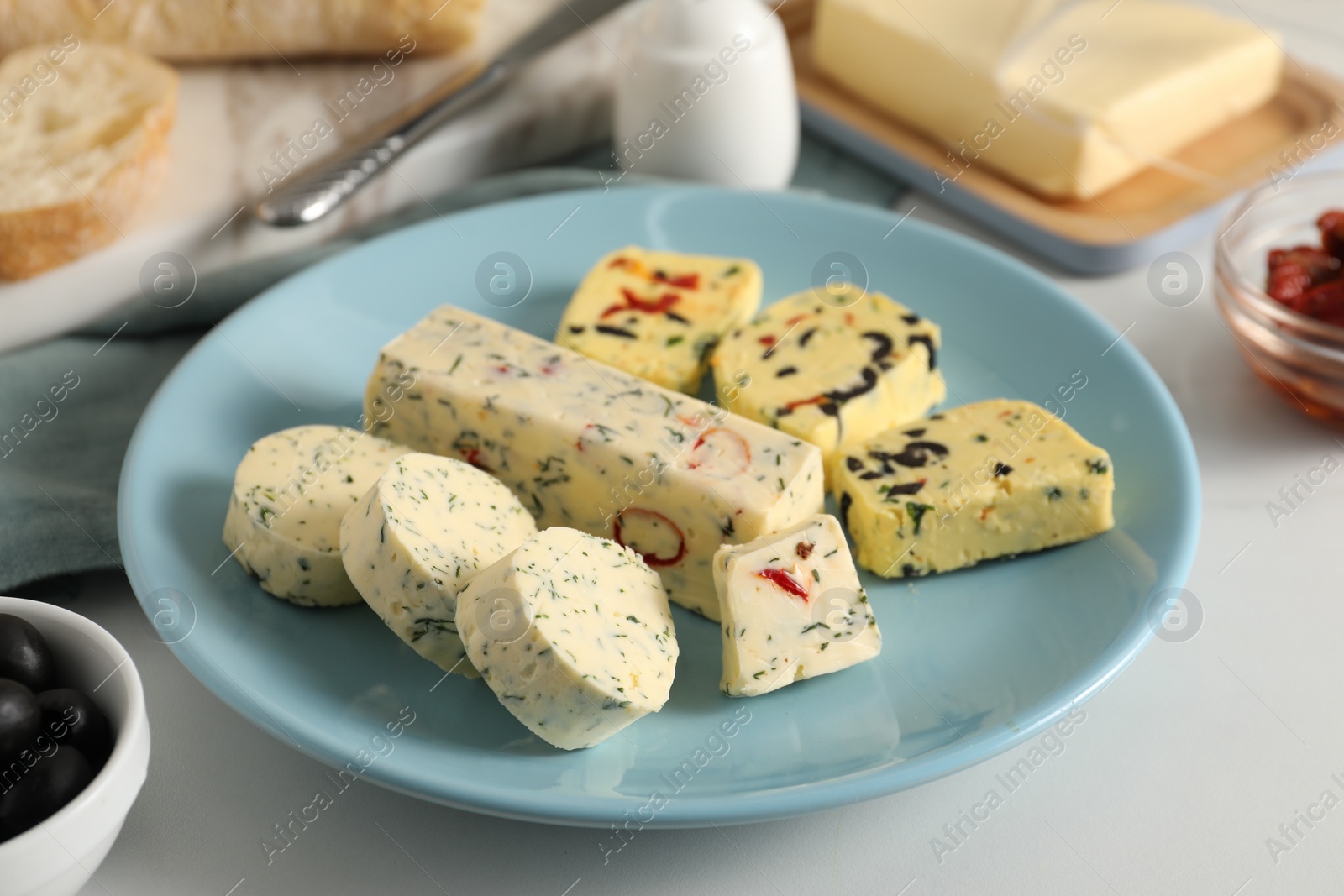 Photo of Different types of tasty butter on white table, closeup