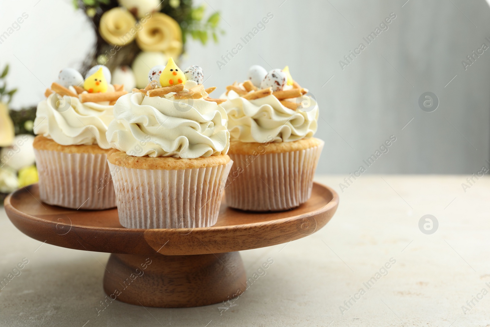 Photo of Tasty Easter cupcakes with vanilla cream on gray table, space for text