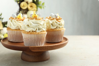 Tasty Easter cupcakes with vanilla cream on gray table, space for text