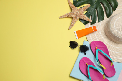 Flat lay composition with beach objects on yellow background. Space for text