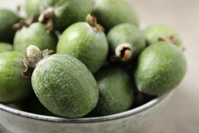 Photo of Fresh green feijoa fruits in bowl, closeup. Space for text