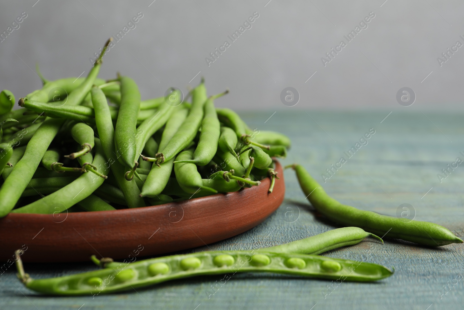 Photo of Fresh green beans on blue wooden table, closeup