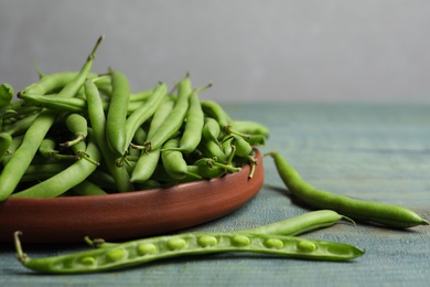 Photo of Fresh green beans on blue wooden table, closeup