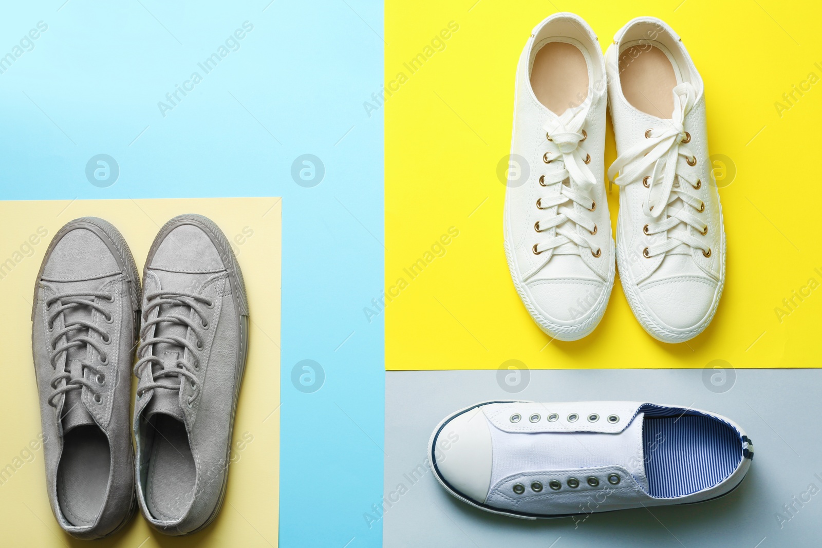 Photo of Flat lay composition with different sneakers on color background