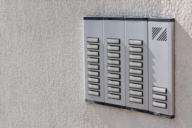 Photo of Intercom station on wall outdoors, space for text. Security system