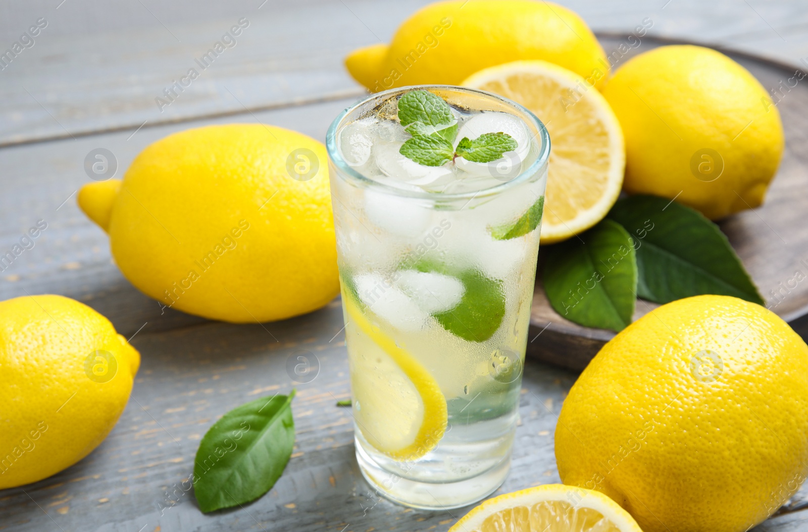 Photo of Cool freshly made lemonade and fruits on grey wooden table