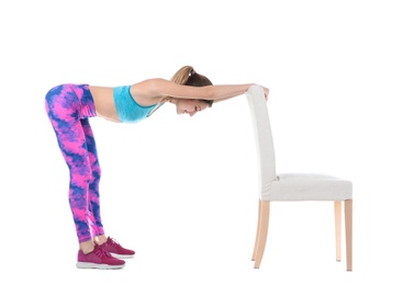 Photo of Young woman exercising with chair on white background. Home fitness