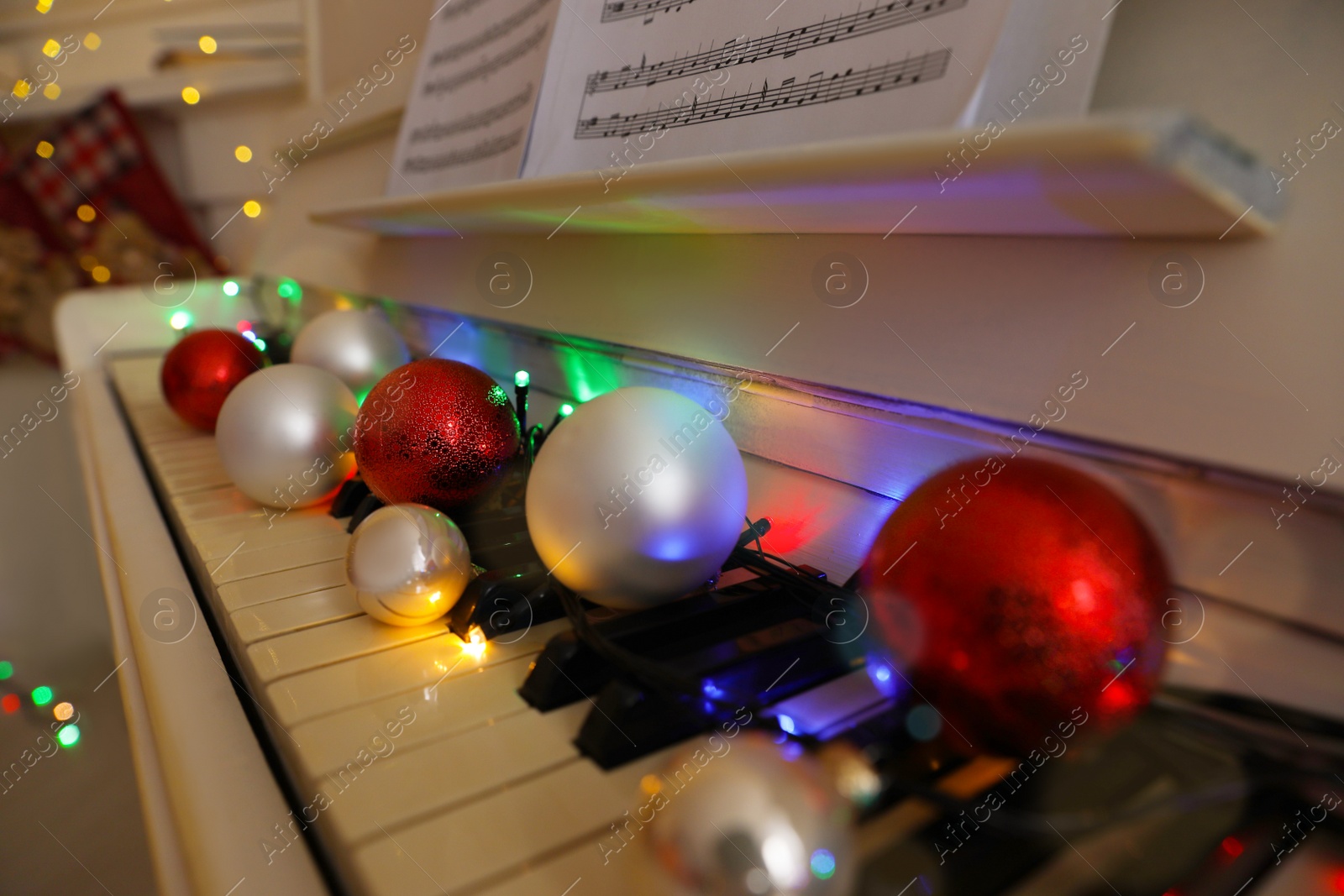Photo of Festive decor on piano keys indoors, closeup. Christmas music