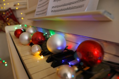 Festive decor on piano keys indoors, closeup. Christmas music