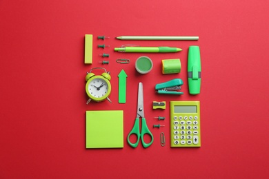 Photo of Green school stationery on red background, flat lay
