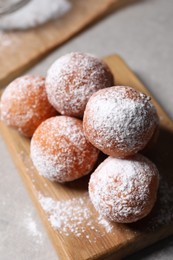 Delicious sweet buns with powdered sugar on gray table