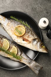 Photo of Delicious baked fish served on grey table, top view