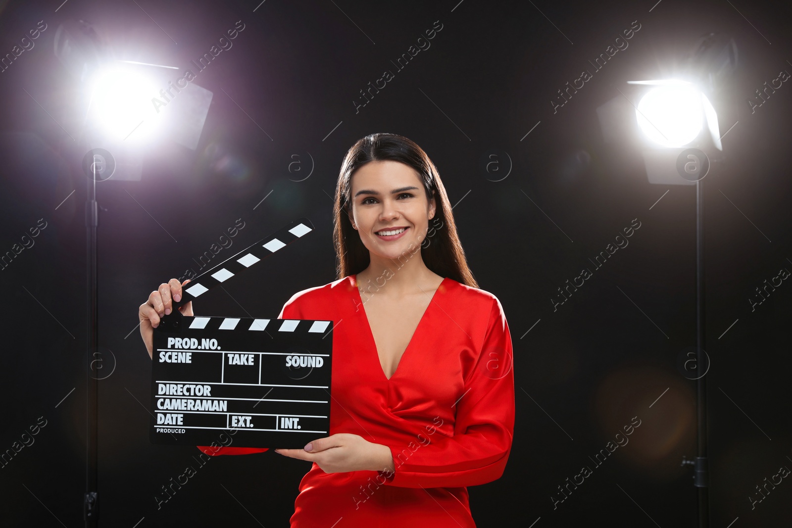 Photo of Happy actress with clapperboard on stage. Film industry