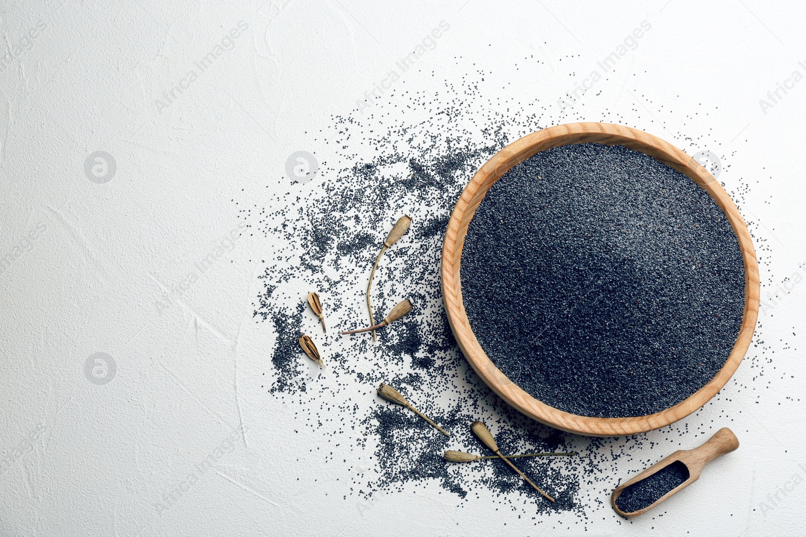 Photo of Dried poppyheads and seeds on white table, flat lay. Space for text