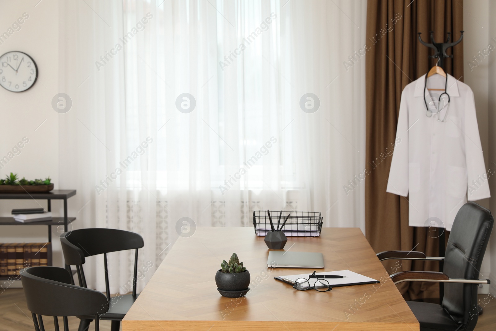 Photo of Modern medical office interior with doctor's workplace and chairs