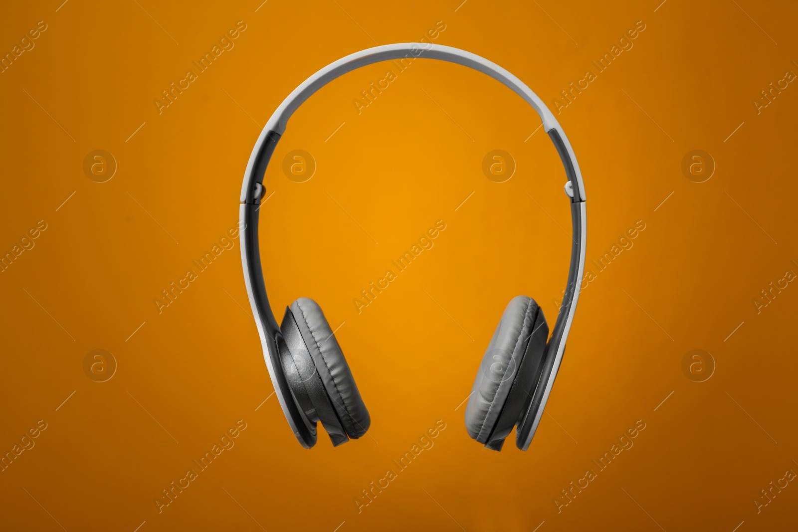 Photo of Wireless headphones with earmuffs on color background