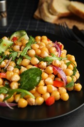 Delicious fresh chickpea salad on black table, closeup