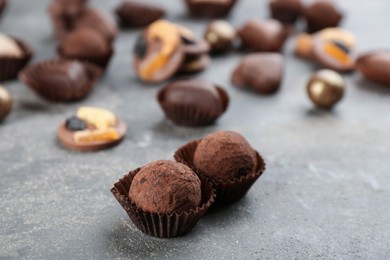 Different delicious chocolate candies on grey table, closeup