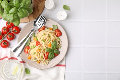 Delicious pasta primavera served on white table, flat lay. Space for text