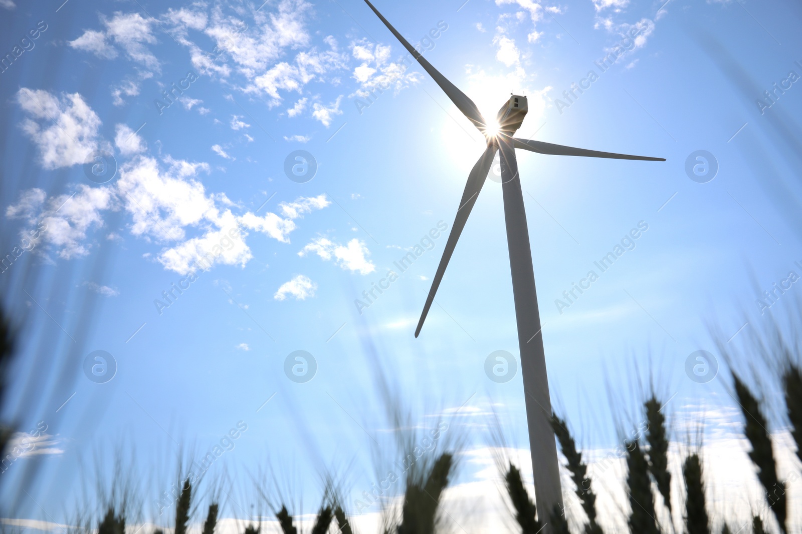 Photo of Wind turbine against beautiful blue sky, low angle view. Alternative energy source