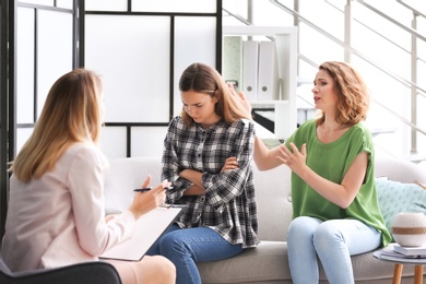 Photo of Young woman and her teenage daughter visiting child psychologist in office