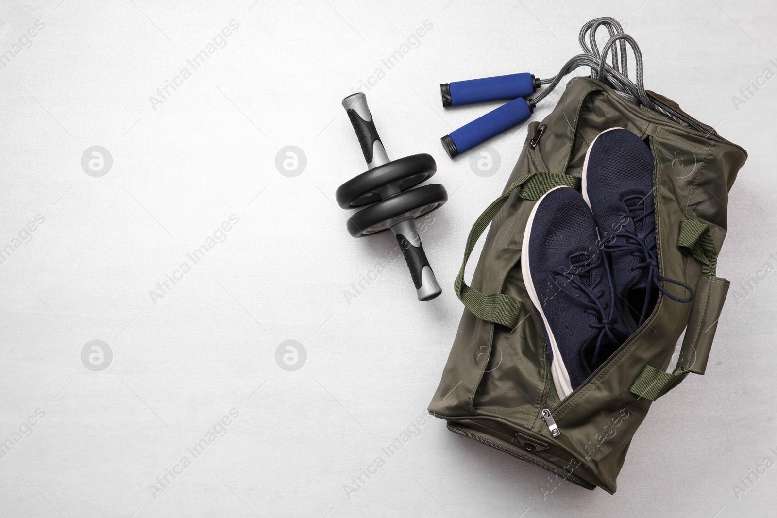 Photo of Gym bag and sports equipment on white background, flat lay. Space for text