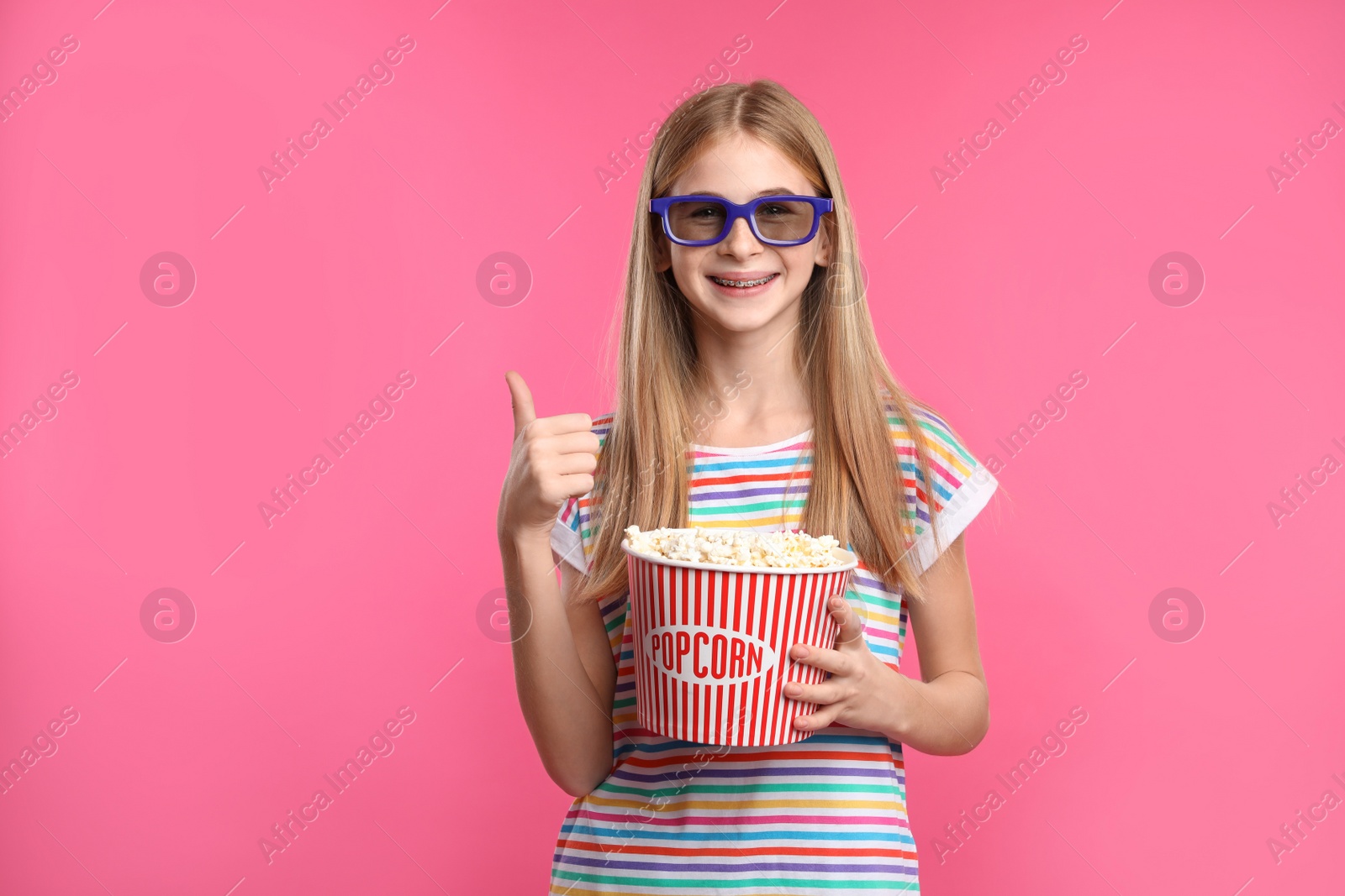 Photo of Teenage girl with 3D glasses and popcorn during cinema show on color background