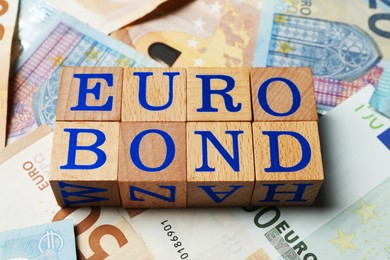 Photo of Wooden cubes with word Eurobond on euro banknotes