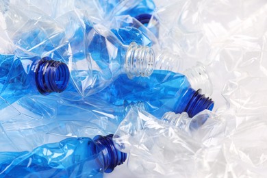 Photo of Crumpled disposable plastic bottles as background, closeup