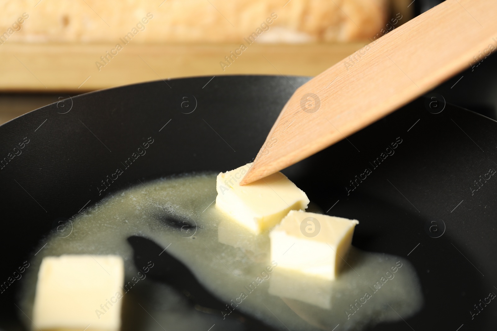 Photo of Stirring melting butter in frying pan, closeup