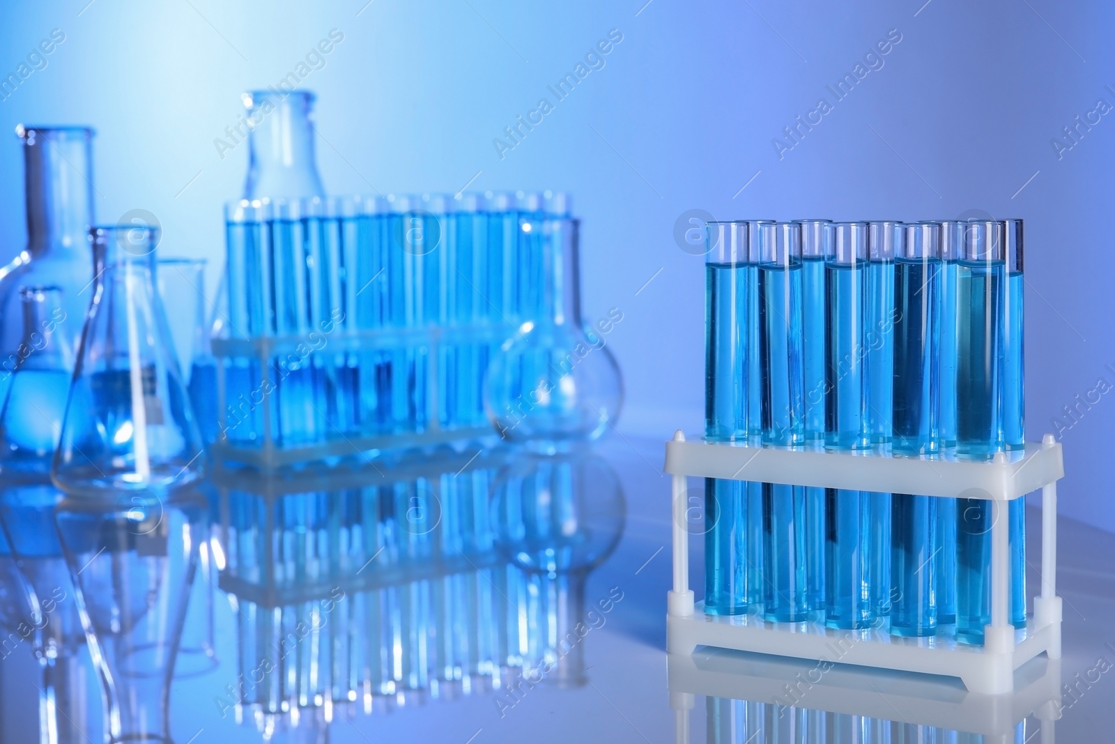 Photo of Holder with test tubes for analysis on table in laboratory. space for text