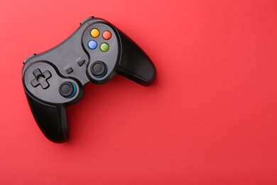 Photo of Wireless game controller on red background, top view. Space for text