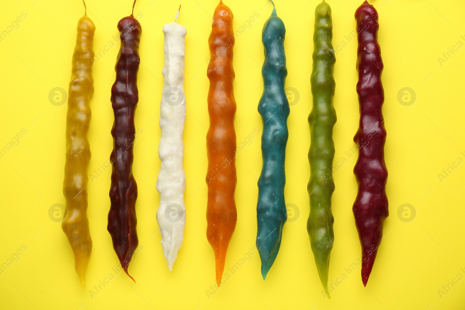 Photo of Many different delicious churchkhelas on yellow background, flat lay