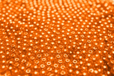 Image of Many bright orange beads as background, closeup