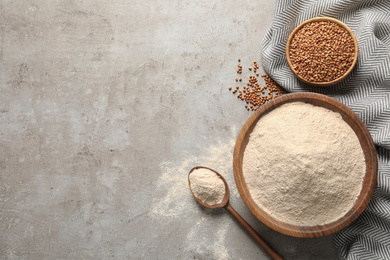 Flat lay composition with buckwheat flour on grey table, space for text