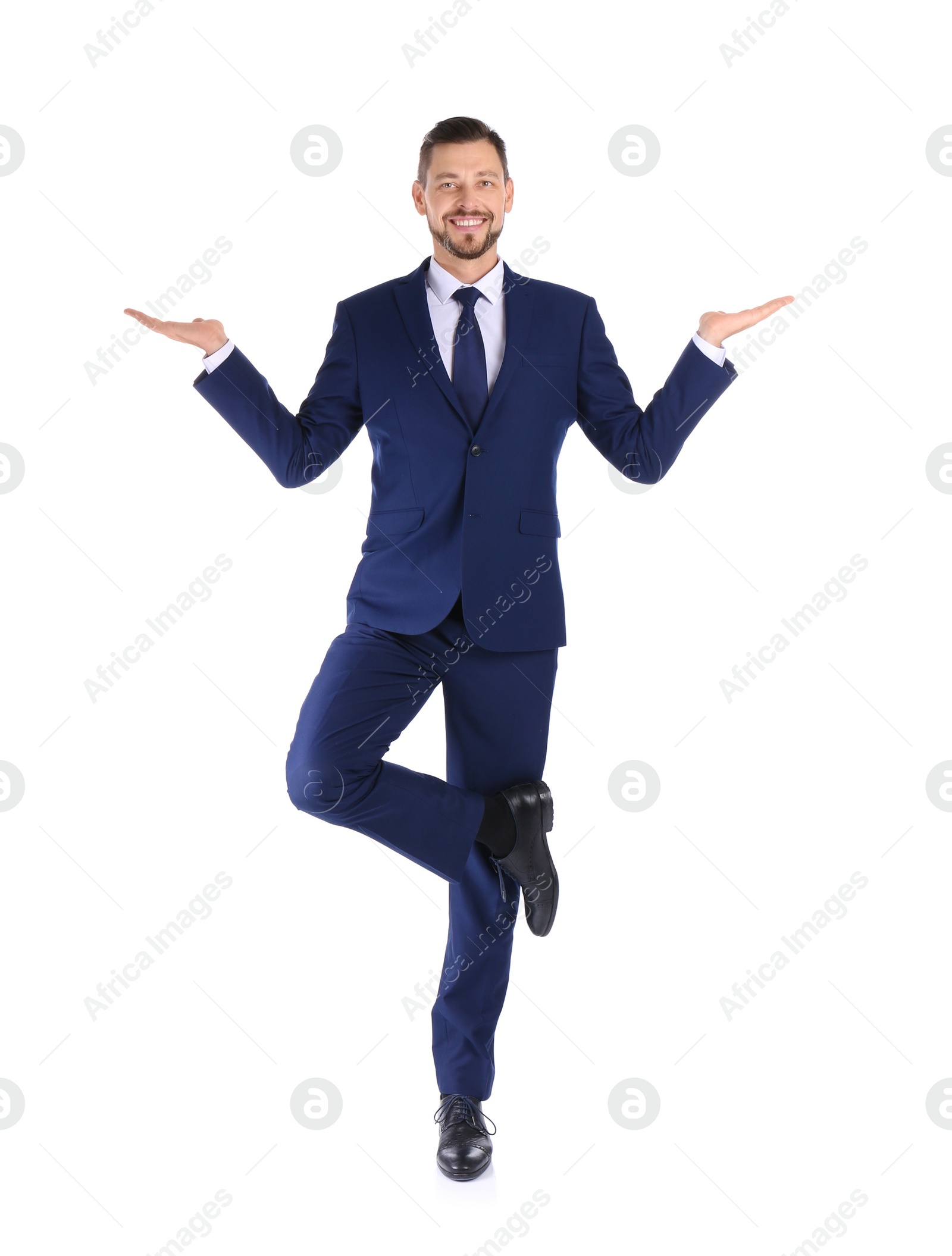 Photo of Full length portrait of businessman balancing on white background