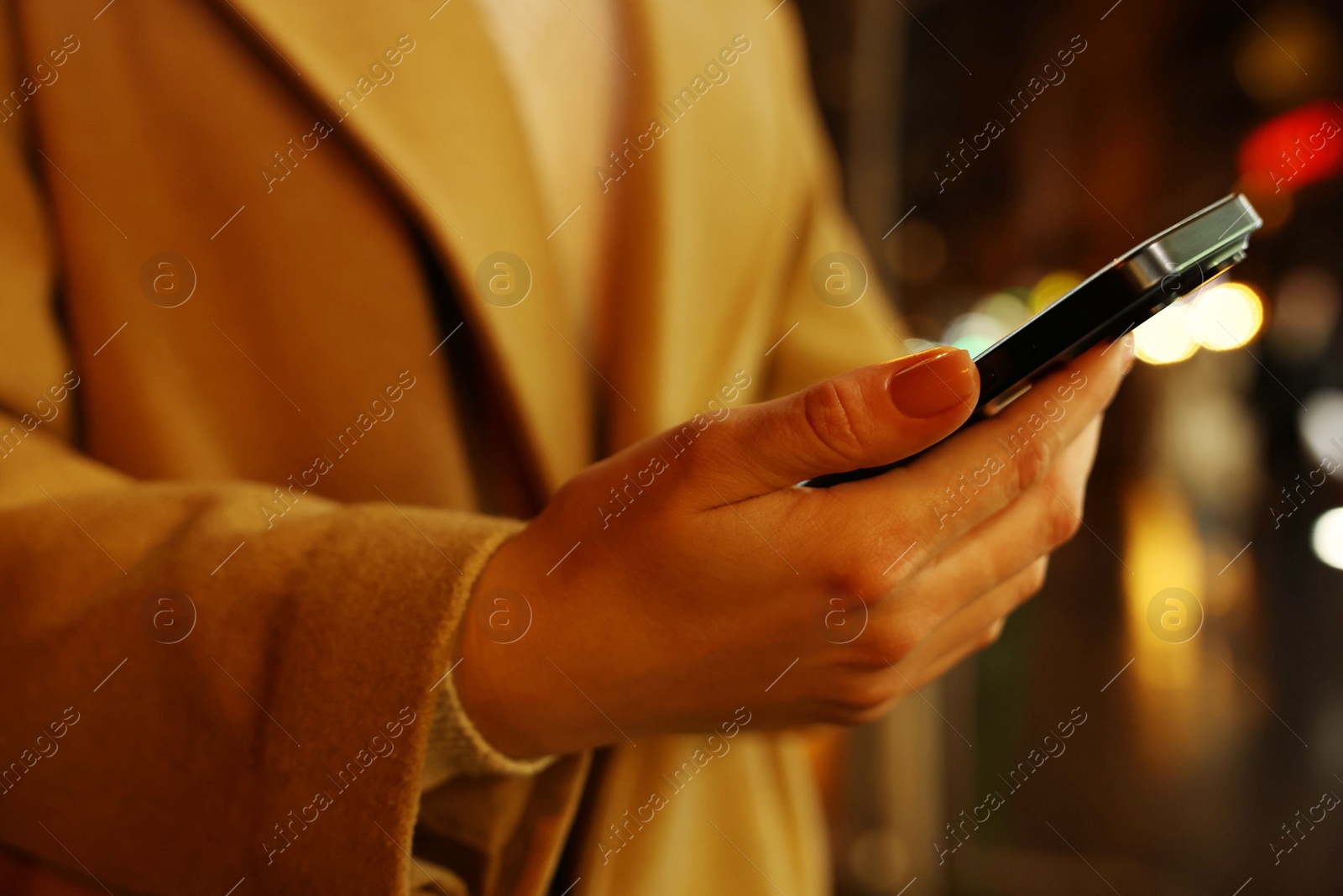 Photo of Woman using smartphone on blurred background, closeup