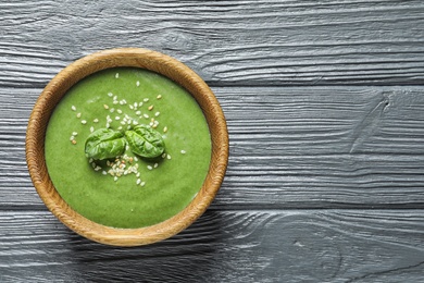 Fresh vegetable detox soup made of spinach in dish on wooden background, top view with space for text