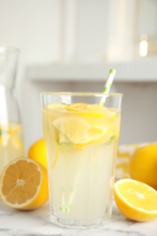 Photo of Cool freshly made lemonade and fruits on white marble table