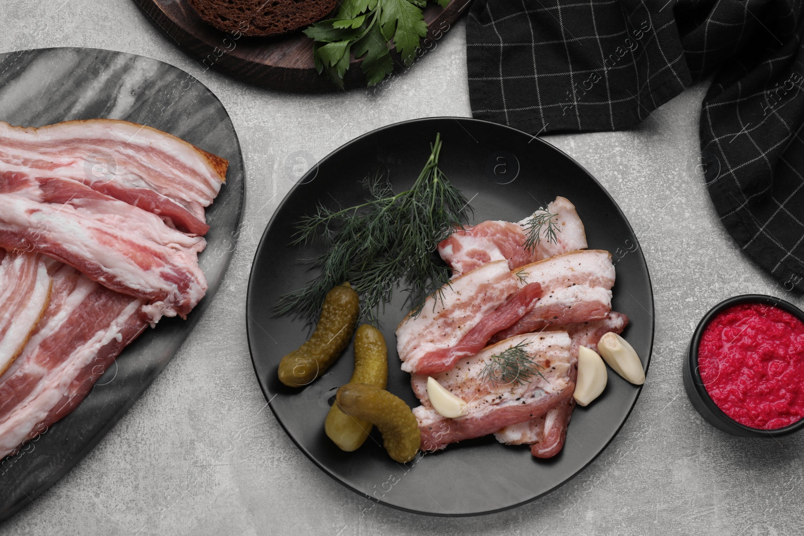 Photo of Tasty pork fatback pickled cucumbers and spices on grey table, flat lay