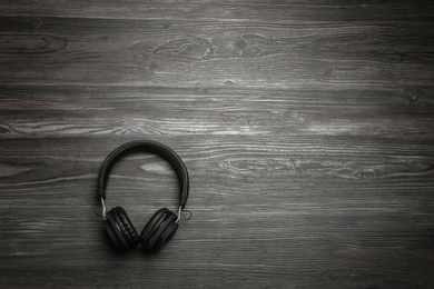 Stylish headphones on wooden background, top view. Space for text