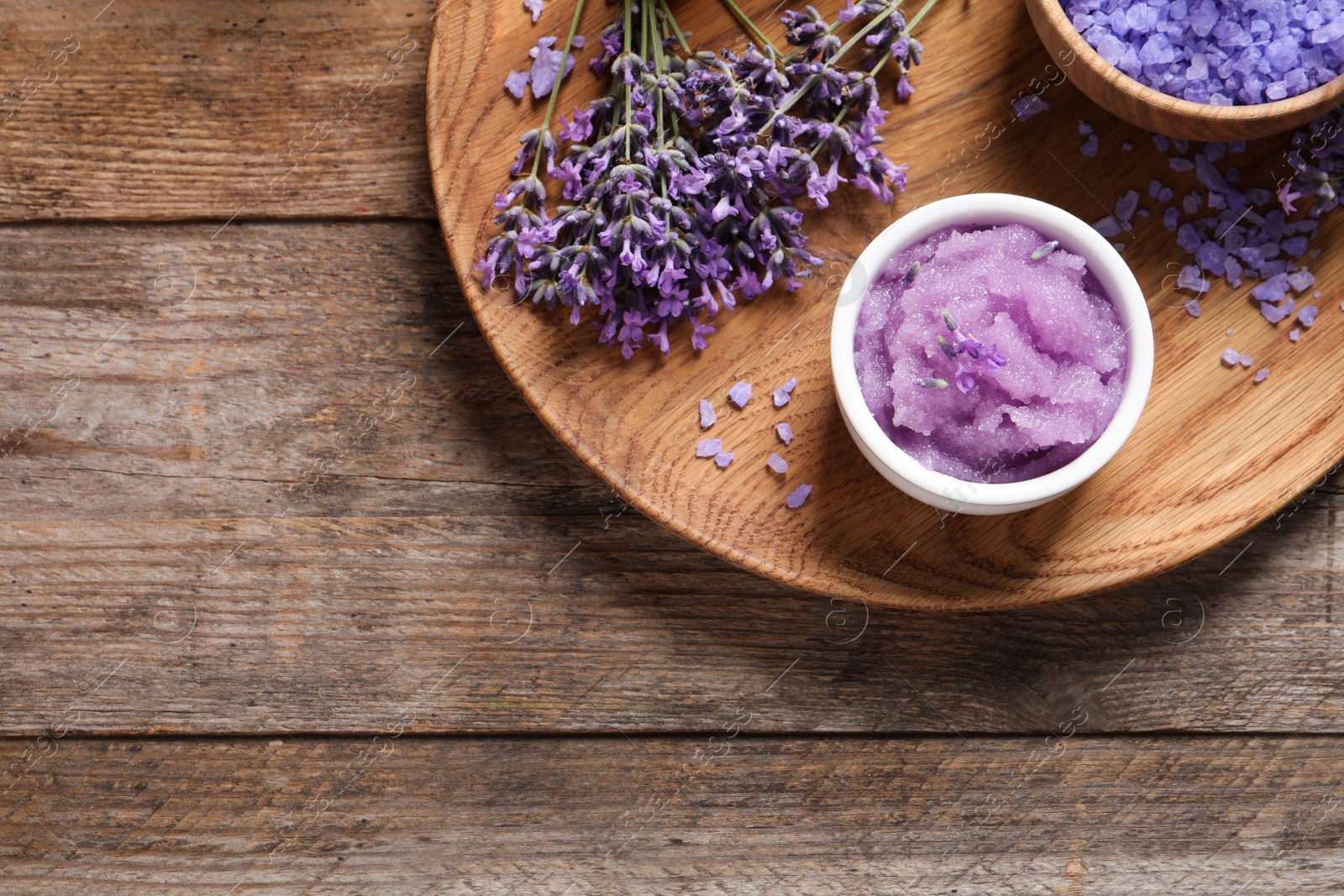 Photo of Plate with natural cosmetic products and lavender flowers on wooden table, top view. Space for text