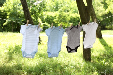 Photo of Baby onesies hanging on clothes line outside